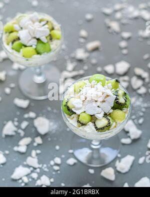 Zwei Sektgläser mit klassischem pavlova, im chaotischen Meringue-Szenenüberblick. Stockfoto