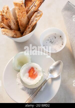 Perfekt weich gekochtes Ei mit Toast und Trüffelsalz.Silberlöffel, natürliches Licht. Stockfoto