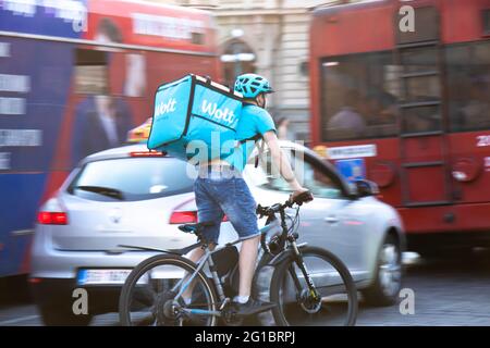 Belgrad, Serbien - 5. Juni 2021: Wolt Food Delivery Service Kurier auf dem Fahrrad im belebten Stadtverkehr Stockfoto