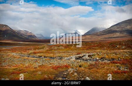 Tolles Tal auf dem Weg des Kungsleden Trail zwischen Salka und Singi mit einer kleinen Brücke über einen Bach, Schwedisch Lappland, Mitte September Stockfoto