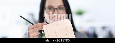 Frau Designerin hält Schimmel mit Skizzen von Kleidung Stockfoto