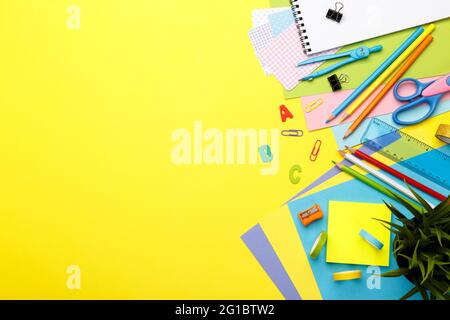 Zurück zum Schulkonzept. Bunte stationäre Schulbedarf auf gelbem Hintergrund, Raum oder Text flach legen Stockfoto