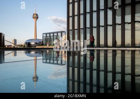 Sonniger Blick im Freien, Spiegelung des Rheinturms auf dem reflektierten Pool im Innenhof zwischen dem Hyatt Regency Düsseldorf Hotel in Düsseldorf, Deutschland. Stockfoto