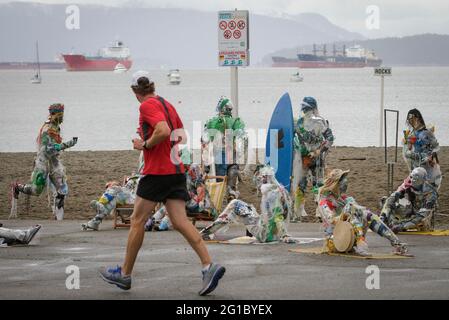 Vancouver, Kanada. Juni 2021. Am 6. Juni 2021 läuft ein Mann an Zahlen vorbei, die aus Kunststoff gefertigt wurden, der am Strand von Kitsilano in Vancouver, British Columbia, Kanada, entfernt wurde. Die von der multidisziplinären Künstlerin Caitlin Doherty geschaffenen Figuren, die aus Plastik an kanadischen Küsten entfernt wurden, verkörpern den kollektiven Beitrag der Menschen zur Plastikverschmutzung und bringen das Thema der Küstenverschmutzung in den Vordergrund. Quelle: Liang Sen/Xinhua/Alamy Live News Stockfoto