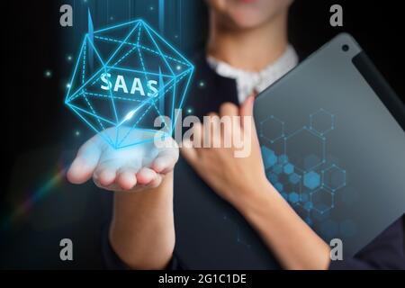Business, Technologie, Internet und Netzwerkkonzept. Junger Geschäftsmann arbeitet auf einem virtuellen Bildschirm der Zukunft und sieht die Inschrift: SAAS Stockfoto