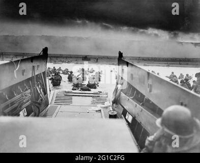 Restauriertes Foto, das amerikanische Soldaten zeigt, die am D-Day, 6. Juni 1944, vom Landungskahn der Küstenwache in Richtung Strand in der Normandie wateten. Sargent, Robert F., 1923-2012, Fotograf. Stockfoto