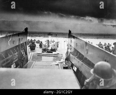 Am D-Day, dem 6. Juni 1944, wateten amerikanische Soldaten vom Landungskahn der Küstenwache in Richtung Strand in der Normandie. Sargent, Robert F., 1923-2012, Fotograf. Stockfoto