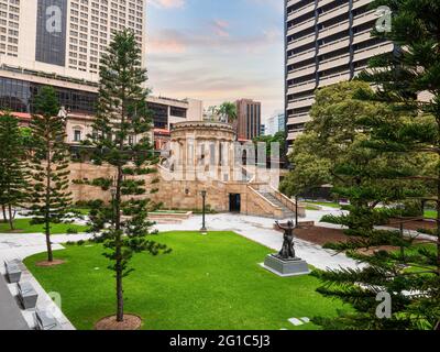 Anzac Platz und Denkmal in Brisbane, Australien. Bäume, grünes Gras, Gebäude, Statue. Stockfoto