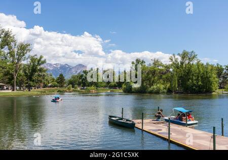 Salt Lake City, Utah - 31. Mai 2021: Der Teich mit einem Bootssteg im Liberty Park in der Innenstadt von Salt Lake City, Utah. Menschen, die auf den Tretbooten fahren Stockfoto