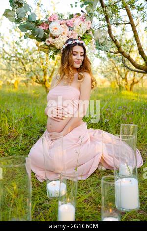 Schöner Bauch der jungen Schwangeren. Schwangerschaft Frau im Garten Stockfoto