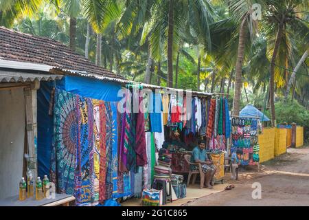 Farbenfroher Stall am Straßenrand unter Palmen, der Kunsthandwerk, Kleidung, Geschenke, Souvenirs, Agonda, Goa, Indien Stockfoto