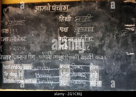 Indische Schrift, die als devanagari oder nagari bekannt ist, geschrieben in einer Tafel auf der Wand des Schulklassenzimmers, Agonda, Goa, Indien Stockfoto