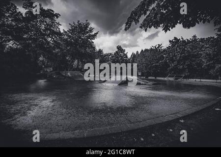 Bikepark und Skatepark auf Schloss Borbeck im verlassenen Skateboard-Park im Regen in düsterem, surreal-monochromen Schwarz-Weiß. Melantere Stimmung. Stockfoto