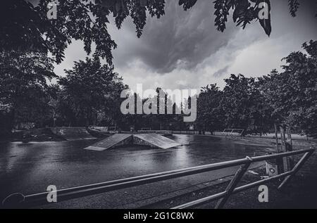 Bikepark und Skatepark auf Schloss Borbeck im verlassenen Skateboard-Park im Regen in düsterem, surreal-monochromen Schwarz-Weiß. Melantere Stimmung. Stockfoto