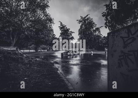 Bikepark und Skatepark auf Schloss Borbeck im verlassenen Skateboard-Park im Regen in düsterem, surreal-monochromen Schwarz-Weiß. Melantere Stimmung. Stockfoto