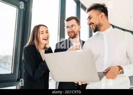 Fröhliche Büroangestellte mit Laptop Stockfoto
