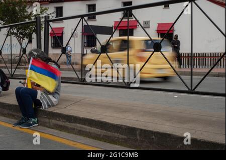 Bogota, Kolumbien. Juni 2021. Eine Frau hält eine kolumbianische Nationalflagge auf dem Kopf, während sich Menschen und indigene Misak-Gemeinschaften versammeln, um angesichts der Brutalität der Polizei und der Unruhen während regierungsfeindlicher Proteste, die im vergangenen Monat an Demonstrationen mindestens 70 Tote erreichten, auf die Ankunft der Interamerikanischen Menschenrechtskommission (CIDH) zu warten. Am 6. Juni 2021 in Bogota, Kolumbien. Kredit: Long Visual Press/Alamy Live Nachrichten Stockfoto