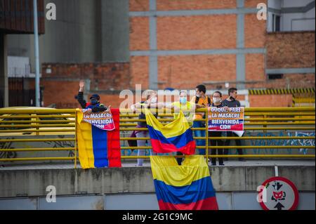 Bogota, Kolumbien. Juni 2021. Demonstranten stehen auf einer Brücke mit kolumbianischen Flaggen und Schildern mit der Aufschrift „Duque STOP the Massaker, Begrüßen Sie die CIDH, während sich Menschen und indigene Misak-Gemeinschaften versammeln, um auf die Ankunft der Interamerikanischen Menschenrechtskommission (CIDH) zu warten, inmitten von Polizeibrutalität und Unruhen während regierungsfeindlicher Proteste, die im vergangenen Monat bei Demonstrationen in Bogota, Kolumbien, mindestens 70 Tote erreichen, am 6. Juni 2021. Kredit: Long Visual Press/Alamy Live Nachrichten Stockfoto