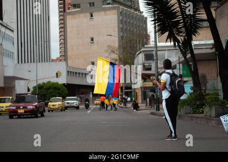 Bogota, Kolumbien. Juni 2021. Ein Mann schwenkt eine kolumbianische Nationalflagge, während sich Menschen und indigene Misak-Gemeinschaften versammeln, um inmitten von Polizeibrutalität und Unruhen während regierungsfeindlicher Proteste, die im vergangenen Monat mindestens 70 Tote erreichten, in Bogota auf die Ankunft der Interamerikanischen Menschenrechtskommission (CIDH) zu warten. Kolumbien am 6. Juni 2021. Kredit: Long Visual Press/Alamy Live Nachrichten Stockfoto