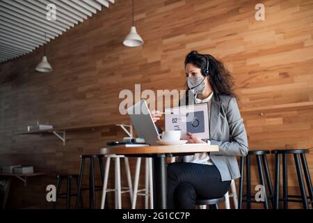 Geschäftsfrau mit Laptop im Café, freiberuflicher Arbeit und Videoanrufanruf-Konzept. Stockfoto
