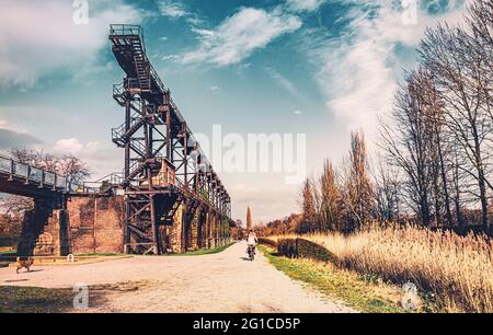 Stahlrahmenbrücke an der Emscher Promenade mitten im Landschaftspark Duisburg Nord. Industriemaschinen und verrostete Komponenten. Ironworks blas Stockfoto