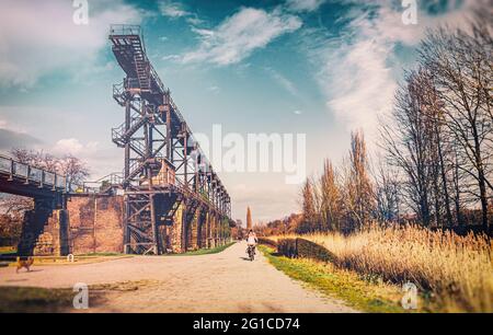 Stahlrahmenbrücke an der Emscher Promenade mitten im Landschaftspark Duisburg Nord. Industriemaschinen und verrostete Komponenten. Ironworks blas Stockfoto