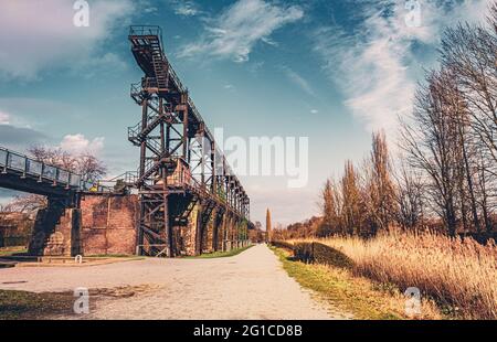 Stahlrahmenbrücke an der Emscher Promenade mitten im Landschaftspark Duisburg Nord. Industriemaschinen und verrostete Komponenten. Ironworks blas Stockfoto