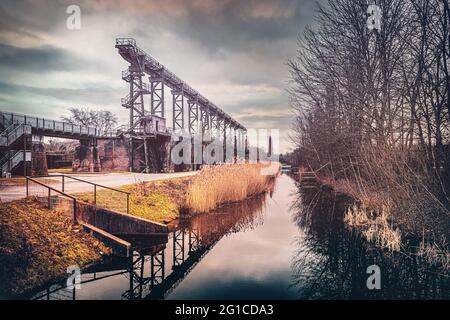 Stahlrahmenbrücke an der Emscher Promenade mitten im Landschaftspark Duisburg Nord. Industriemaschinen und verrostete Komponenten. Ironworks blas Stockfoto