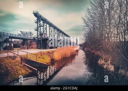 Stahlrahmenbrücke an der Emscher Promenade mitten im Landschaftspark Duisburg Nord. Industriemaschinen und verrostete Komponenten. Ironworks blas Stockfoto