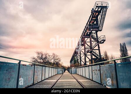 Metall- und Stahlpromenade auf der Emscher in zentraler Perspektive. Landschaftspark Duisburg. Industriemaschinen und verrostete Bauteile im Ruhrgebiet. Stockfoto