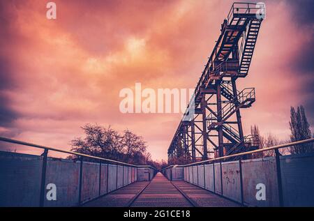 Metall- und Stahlpromenade auf der Emscher in zentraler Perspektive. Landschaftspark Duisburg. Industriemaschinen und verrostete Bauteile im Ruhrgebiet. Stockfoto