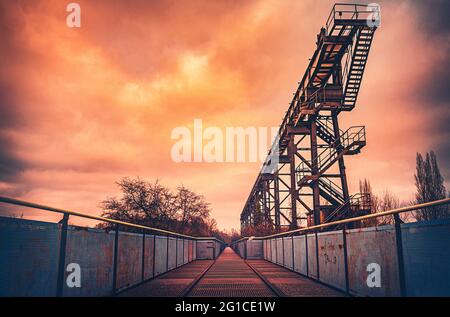 Metall- und Stahlpromenade auf der Emscher in zentraler Perspektive. Landschaftspark Duisburg. Industriemaschinen und verrostete Bauteile im Ruhrgebiet. Stockfoto