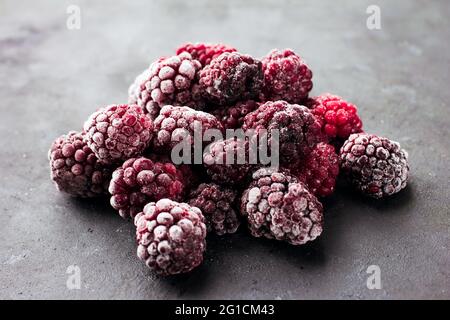 Nahaufnahme von gefrorenen Brombeeren auf dunklem Hintergrund gesunde Lebensmittel Vitamine Snack Dessert Stockfoto