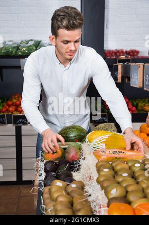 Mann, der Obst im Lebensmittelgeschäft wählt Stockfoto