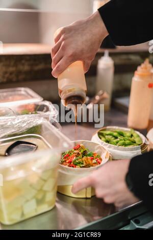 Männlicher Koch bereitet Essen in der Küche zu Stockfoto