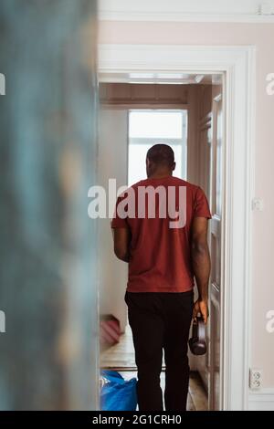 Rückansicht des Mannes, der an der Tür steht Stockfoto
