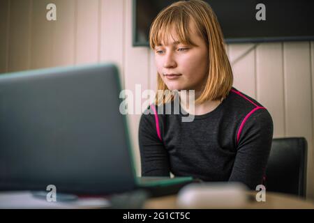 Mädchen E-Learning durch Laptop im Wohnzimmer zu Hause Stockfoto