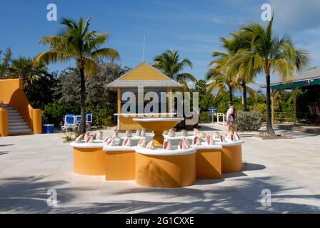 Informationstisch im Half Moon Cay, Bahamas, mit Pool und Brunnen vor dem Hotel, mit Muschelschalen, die zur Dekoration am oberen Rand montiert sind Stockfoto