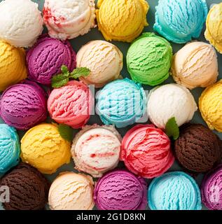 Eine Auswahl an Eiswürfeln. Bunte Eiscreme in verschiedenen Geschmacksrichtungen. Blick von oben auf Eis isoliert mit Minze, Sauce Stockfoto