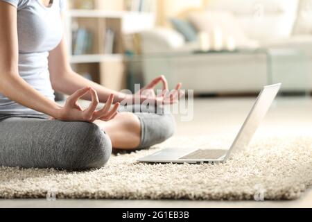 Nahaufnahme einer Frau, die zu Hause Yoga-Übungen macht und sich das Online-Videotutorial auf dem Laptop ansieht Stockfoto