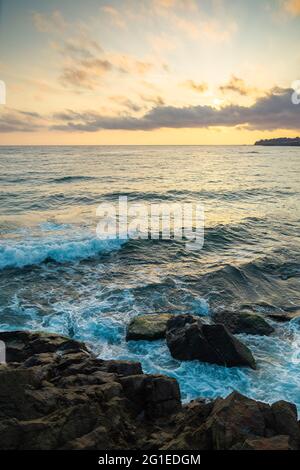 Landschaft am Meer. Schöner Naturhintergrund im Herbst bei Sonnenaufgang. Wolken am Himmel über dem Horizont im Morgenlicht. Wasserwellen krachenden Küsten Stockfoto