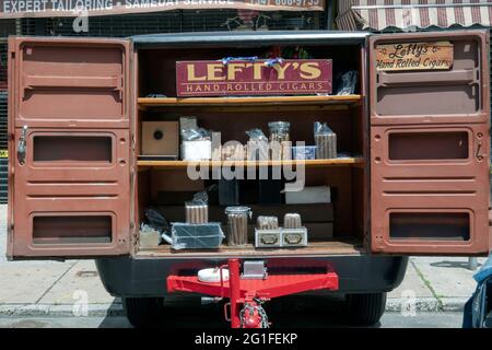 Auf einer Straßenmesse in Astoria Queens verkauft Lefty handgerollte Zigarren aus einem kleinen Anhänger. Stockfoto