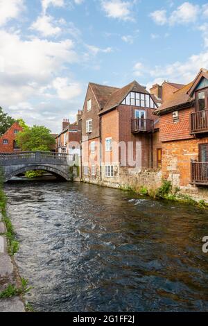 Der Fluss Itchen, der durch die Wehre in Winchester, Hampshire, Südengland fließt, sah in Richtung City Mill und der historischen Steinbrücke auf der Bridge Street Stockfoto