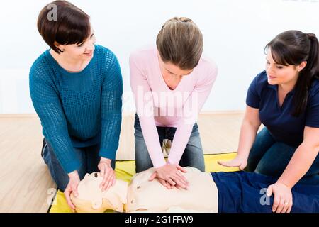 Gruppe von Frauen in Erste Hilfe Kurs Ausübung lebenserhaltende Maßnahmen Stockfoto