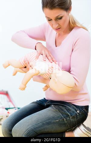 Frau in Erste Hilfe Kurs üben Wiederbelebung des Säuglings auf Baby Doll Stockfoto
