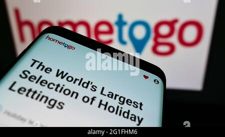 Handy mit Website der deutschen Suchmaschine HomeToGo GmbH auf dem Bildschirm vor dem Logo. Konzentrieren Sie sich auf die obere linke Seite des Telefondisplays. Stockfoto
