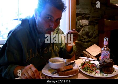 Das Tea Garden Cafe, Restaurant, Mann, Mann isst Cullen-Skink, dicke schottische Suppe aus geräuchertem Schellfisch, Fischsuppe, Haggis mit gebackenen Kartoffeln, schottisch Stockfoto