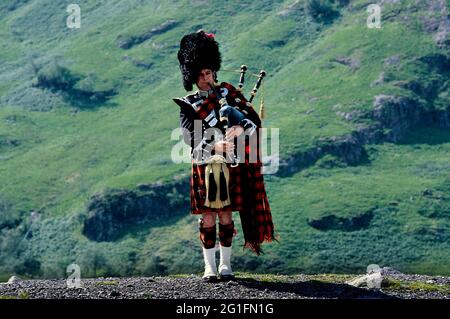 Piper, Dudelsackläufer, Dudelsackläufer, Kilt, Tartan, Dudelsack, Bärenfellkappe, Sporran, Glen Coe Valley, Highlands, highland, Schottland, Großbritannien Stockfoto