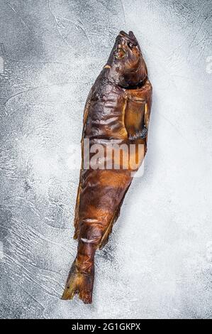 Heißer geräucherter ganzer Fisch auf dem Küchentisch. Weißer Hintergrund. Draufsicht Stockfoto