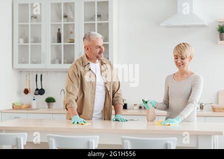 Positives Paar, das gemeinsam Hausaufgaben macht, redet und genießt die Freizeit auf der covid-19 Stockfoto